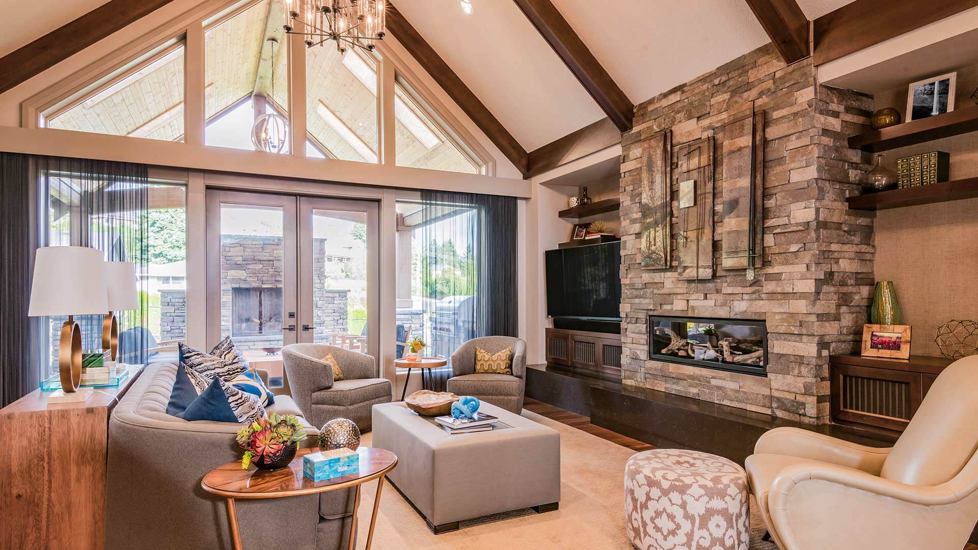 Modern living room featuring a slanted cathedral ceiling supported by solid wood rafters, and a fieldstone-veneer fireplace. 