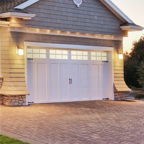 White garage doors in the front of the modern home