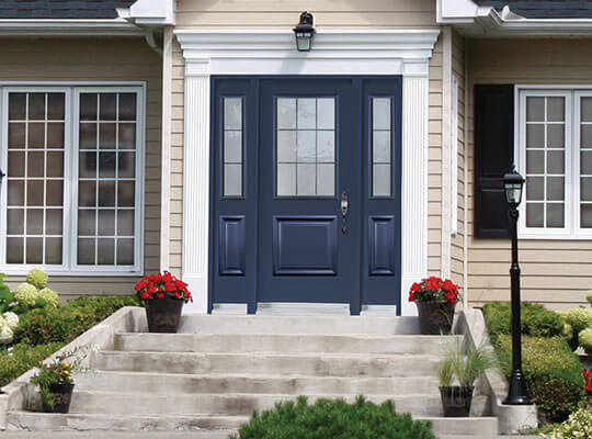 A navy blue fibreglass door with double sidelites on a modern home
