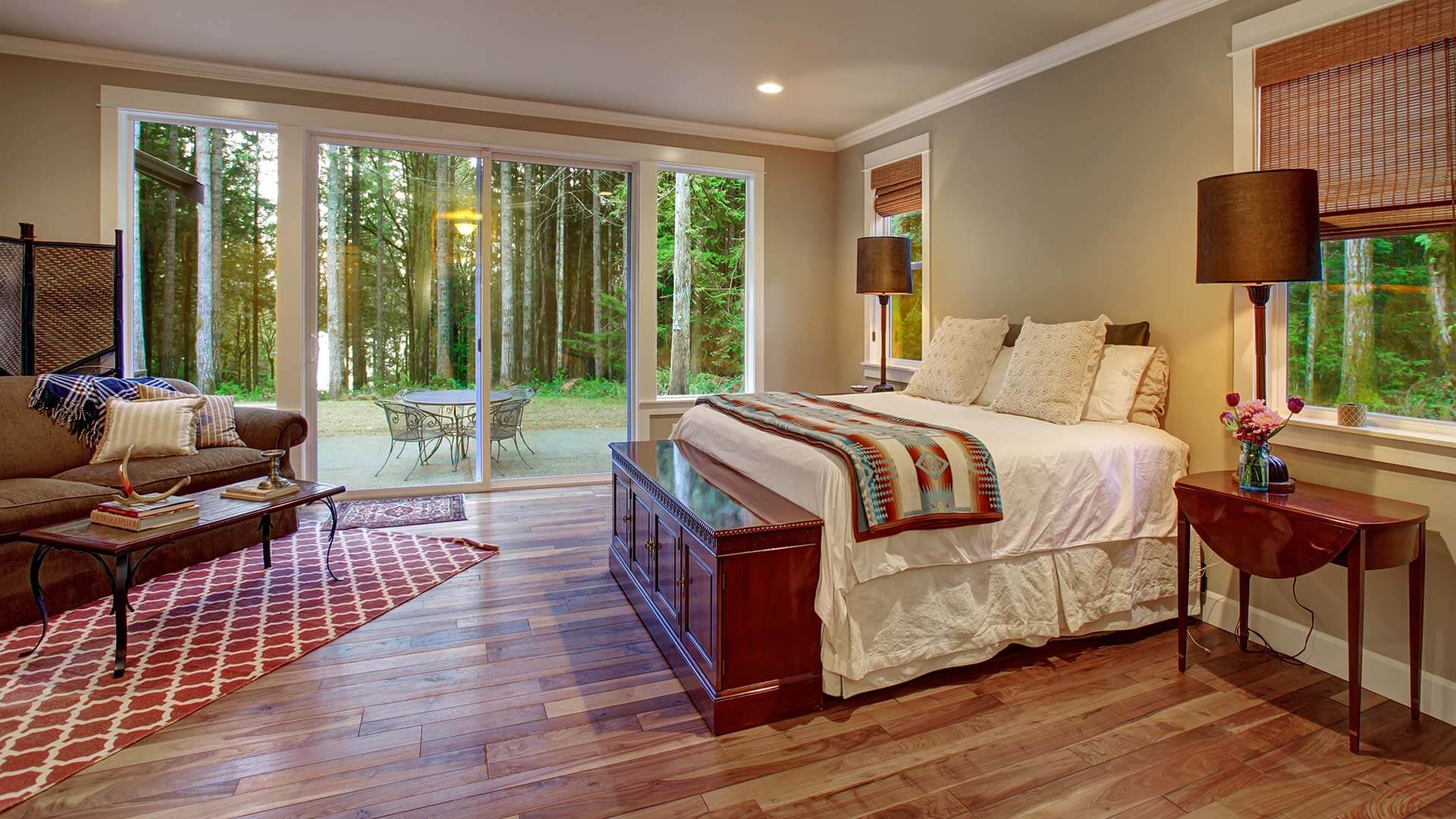 Patio doors with sidelites installed in a bedroom with rustic wood flooring.