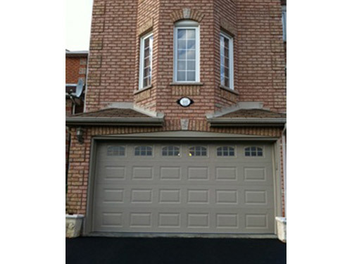tan garage door with three windows above