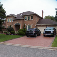 two car garage home with three small windows and arched doorway