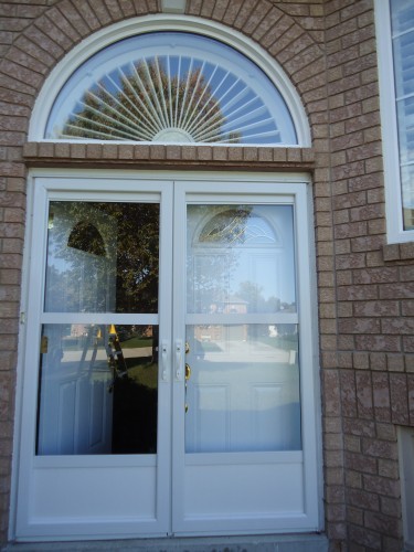 white storm doors with arch window overhead