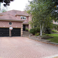 brick house with two car garage doors and shaped window