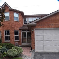 brick home with white garage doors closer view