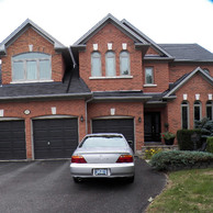 brick home with three brown garage doors