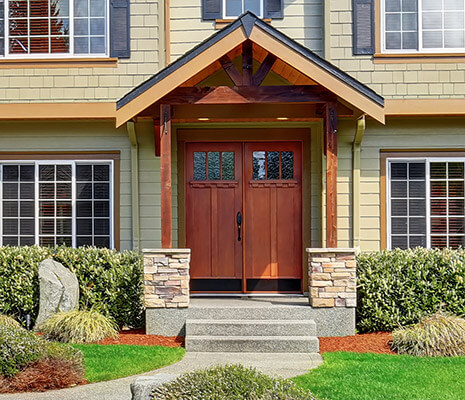 Large, reddish-brown, double-wide door on a traditional home