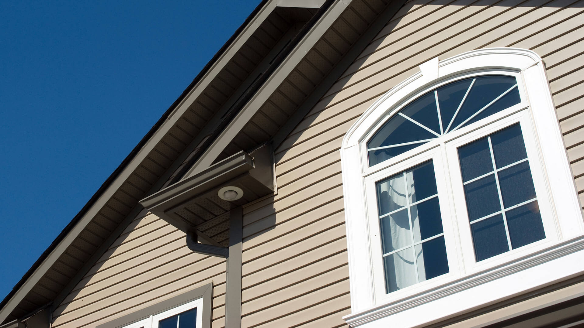 A custom shaped window with detailed exterior trim applied for a finished look.