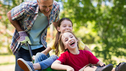 Kids playing outside with their dad.