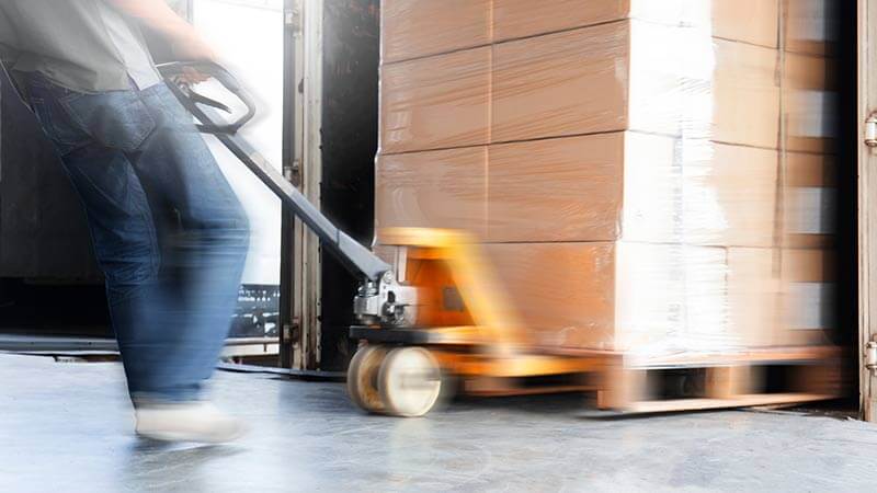 A photo of a pallet truck pulling a pallet filled with boxes