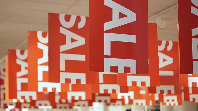 A photo of sale banners hanging in a retail store.