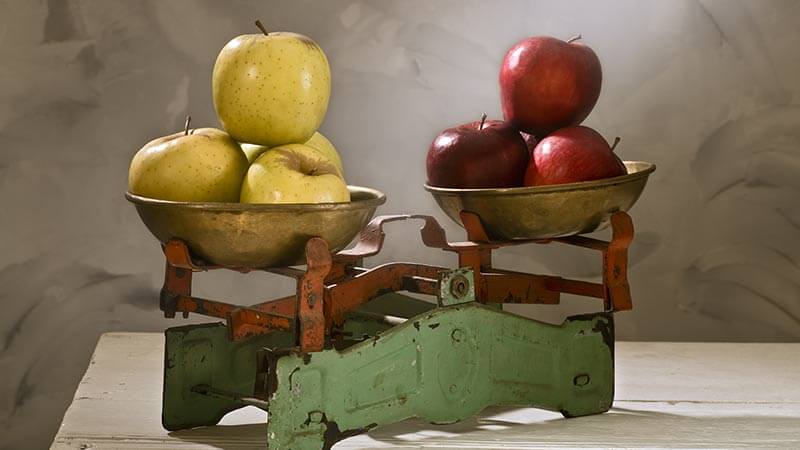 A photo of a balanced scale holding apples