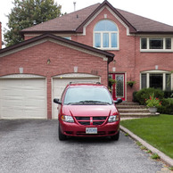 two garage door home with red door and shaped upper window