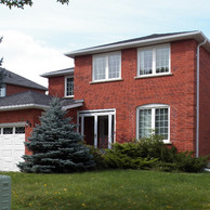 red brick home with two car garage door and enclosure