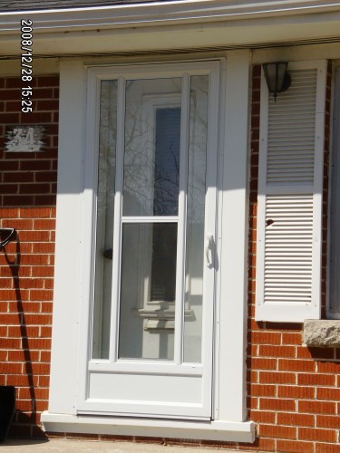 white storm door on brick house