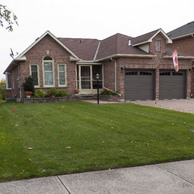 dark brown garage doors and windows with tan trim