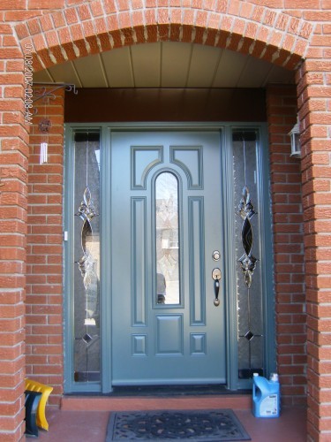 green steel entry door in archway