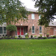 brick house with two car garage doors and shaped window