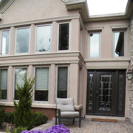 house facade with casement windows and brown entry door