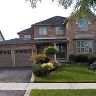 brick home with bay window, shaped window and double entry door