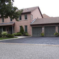 brick home with three garage doors