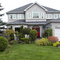 white brick home with red front doors