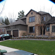 stone home with pergola over front door