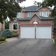 home with two white garage doors and casement windows