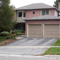 brick home with two garage doors and upper bay window