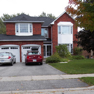 red brick home with all white windows and doors