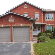 red brick house with two garage doors and white front door