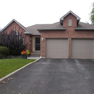 brick home with tan garage doors