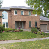 brick house with two car garage doors and shaped window